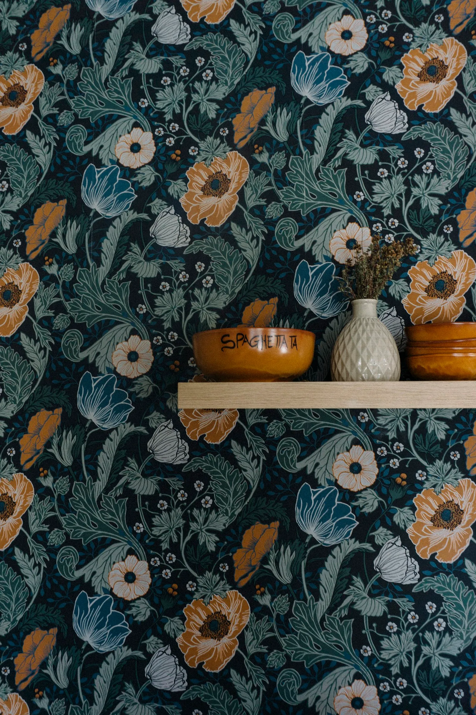 Muur met bloemenbehang en een wandplankje