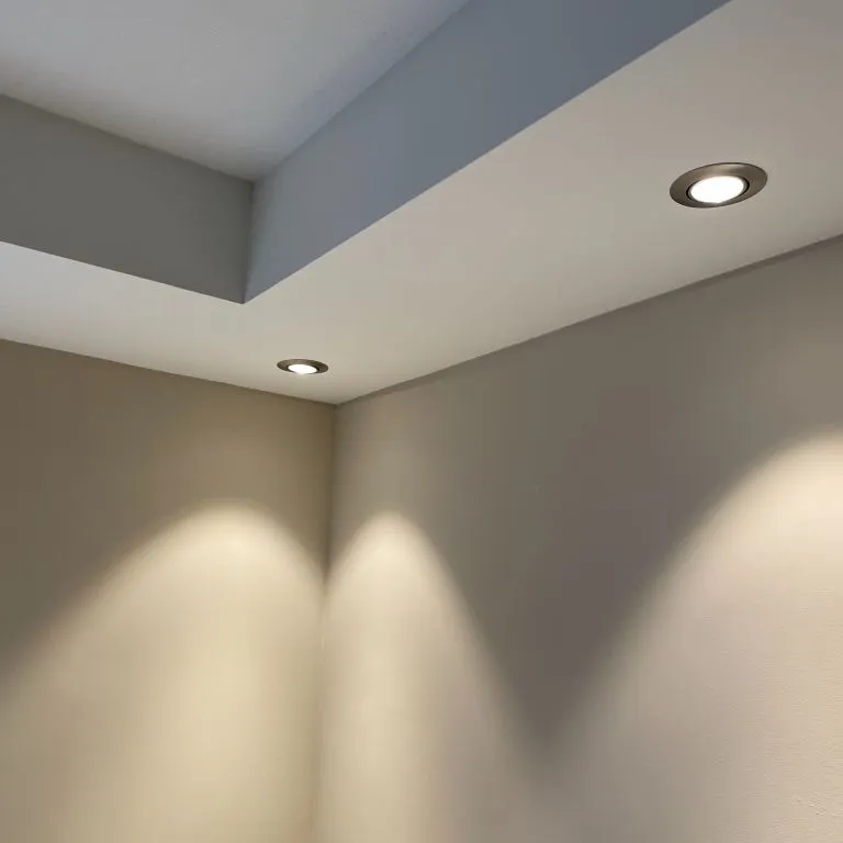 Strak gesausd plafond met verlaagde rand en inbouwspots boven lichte wanden